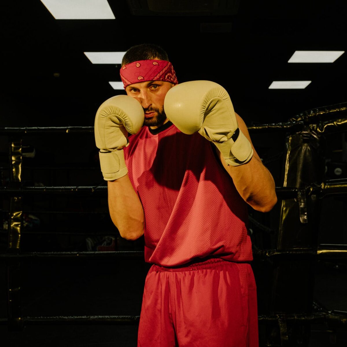 serious young male boxer training on ring